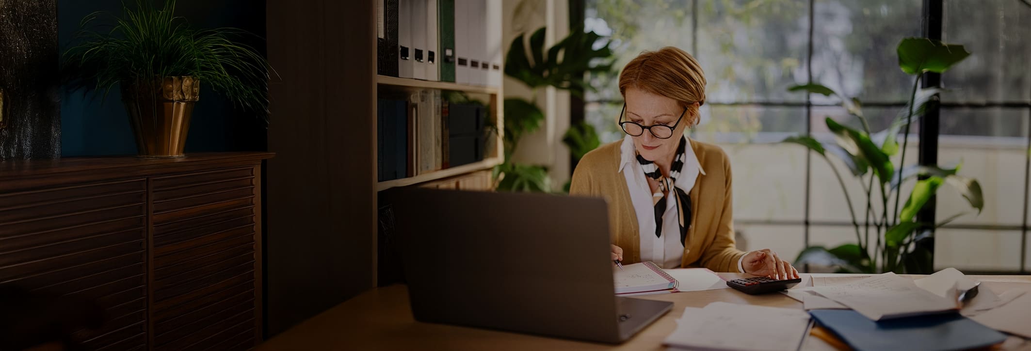 Professional reviewing finances and paperwork at her desk