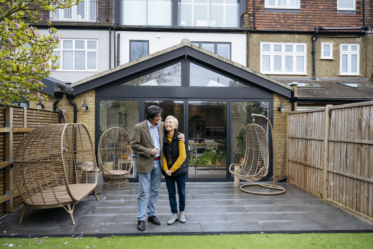 Couple outside their new home following a successful house purchase